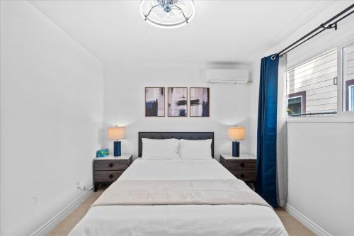 a white bedroom with a bed and a window at 20 percent OFF Cozy Modern Suite in Tustin