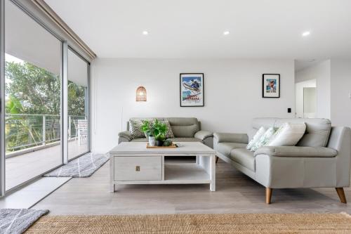 a living room with a couch and a table at Luxury Spacious 3 Bedroom Apartment - Gold Coast in Gold Coast