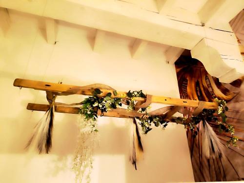 un instrument en bois accroché à un mur avec des fleurs dans l'établissement Mas L'Escale des Dentelles, à Aubignan
