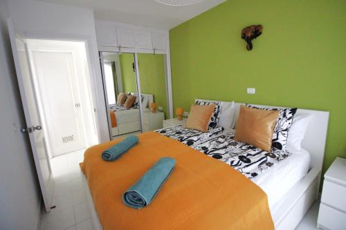a bedroom with a large bed with towels on it at Sonja Apartman in Mogán