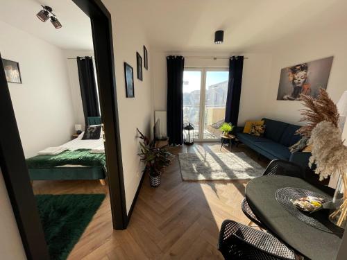 a living room with a mirror and a blue couch at Ami Luxury Residence XII CENTRUM - możliwość REJSU ŁODZIĄ in Iława