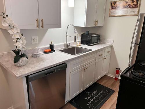 une cuisine avec un évier et un micro-ondes dans l'établissement Modern 1BR Porchlight retreat, à Farmington Hills