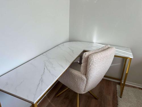 un bureau en marbre avec une chaise et un plateau en verre dans l'établissement Modern 1BR Porchlight retreat, à Farmington Hills