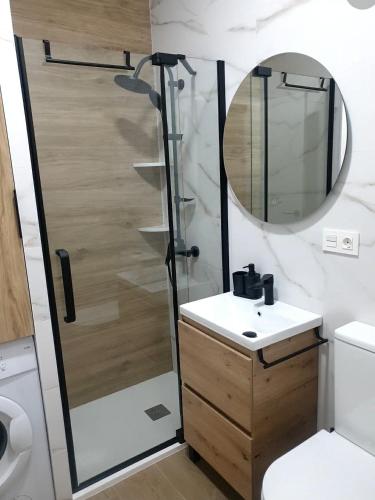 a bathroom with a shower and a sink and a mirror at Bright Apartment AM in Bollullos par del Condado
