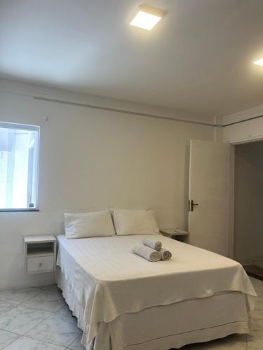 een slaapkamer met een wit bed met handdoeken erop bij Apatapamento 2 quartos com excelente localização, segurança e com tudo o que você e sua família precisam pra uma estadia confortável! in Feira de Santana