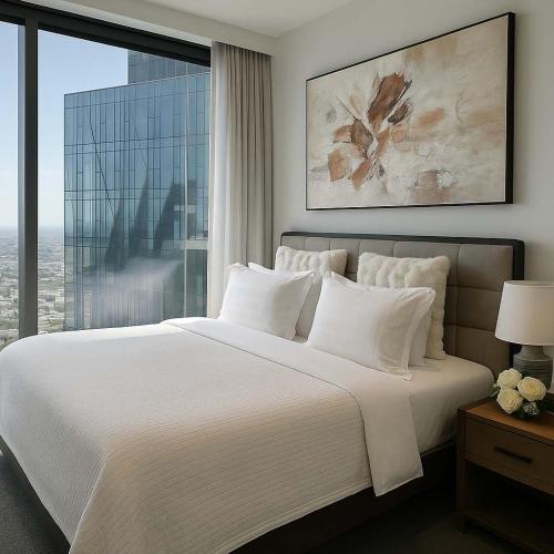 a bedroom with a large bed with a large window at Skyline Grandeur Executive residence by Ritz in Melbourne