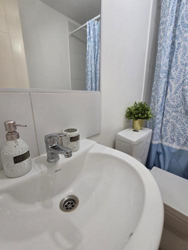 un bagno con un lavandino bianco e un water di Confortable Departamento Familiar 3 Dormitorios a Rancagua