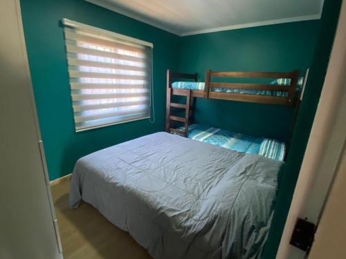 a bedroom with two bunk beds and a green wall at Casa Pichilemu in Pichilemu