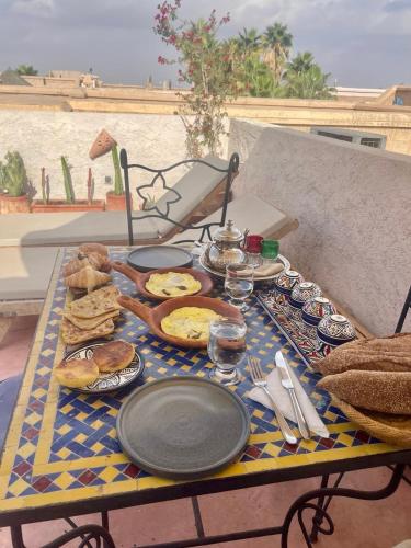 ein Tisch mit Tellern voller Essen auf einem Tisch in der Unterkunft Riad Dar Malwan Hotel and Massage in Marrakesch