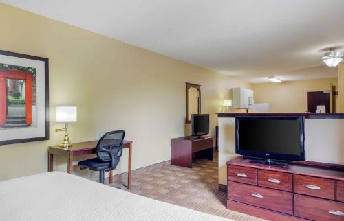 a hotel room with a bed and a flat screen tv at Extended Stay America Suites - Orlando - Orlando Theme Parks - Major Blvd in Orlando