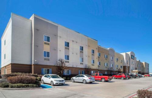 a large building with cars parked in a parking lot at Extended Stay America Suites - Houston - IAH Airport in Houston