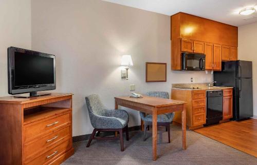 a room with a kitchen with a table and a television at Extended Stay America Suites - Houston - IAH Airport in Houston