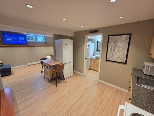une pièce avec une cuisine avec une table et un réfrigérateur dans l'établissement NEW Midtown Rossland Studio Apartment, à Rossland
