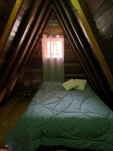a bed in a tent with a window at Chalé Mirante das Estrelas in Camanducaia