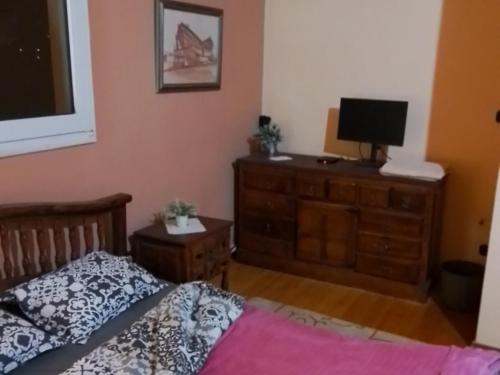 a bedroom with a bed and a television on a dresser at Rooms direct at Metro pallini 200 meter from Train Station and 3 station to Airport and central station to go anywhere to all Athens from here in Pallíni