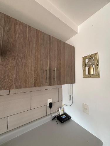 cocina con armarios de madera y teléfono en la pared en Reforma Sky Flat - Steps from Bellas Artes, en Ciudad de México