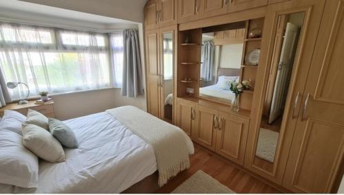 une chambre avec un lit et un grand miroir dans l'établissement The Bliss House Peaceful Retreat Close Transport Links Central London in 15mins Close to Heathrow Airport, à Harrow on the Hill