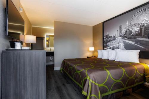 a hotel room with a bed and a picture of a wheel at Super 8 by Wyndham Rockford South in Rockford