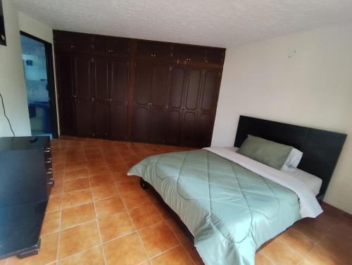a bedroom with a bed with a wooden wall at Casa de hospedaje Lili - Cali in Cali