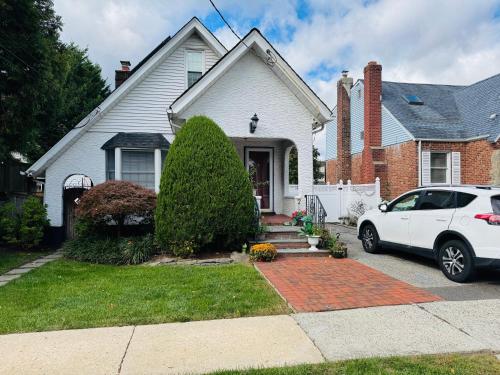 a white car parked in front of a house at Beautiful 2 Bedroom Suite in West Hempstead