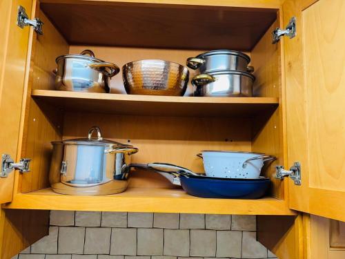 a cupboard filled with pots and pans in a kitchen at Beautiful 2 Bedroom Suite in West Hempstead
