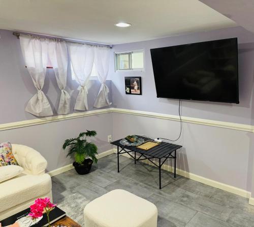 a living room with a flat screen tv on a wall at Beautiful 2 Bedroom Suite in West Hempstead