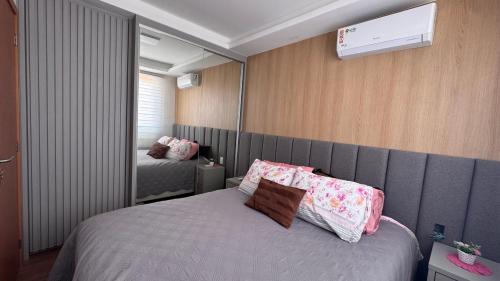 ein Schlafzimmer mit einem großen Bett und einem Spiegel in der Unterkunft Apê pé na areia com vista mar e próximo ao Beto Carrero - Condomínio Vila Açoriana in Barra Velha