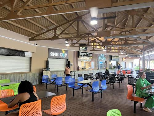 una caffetteria con sedie e tavoli e persone sedute di 4B Holiday Haven a Buccoo