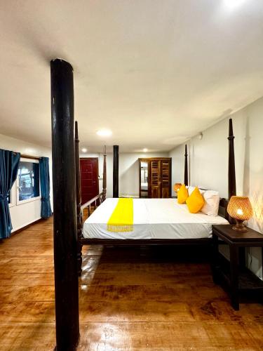 una camera da letto con un letto grande con cuscini gialli di Cozy Paradise a Battambang