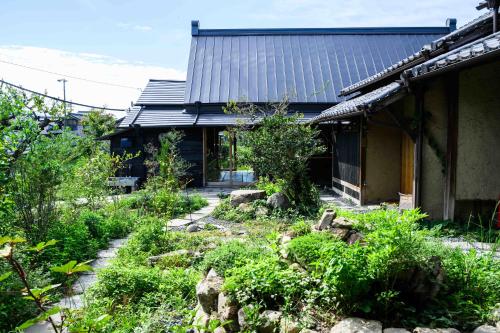 an old house with a garden in front of it at cofunia - Five Elements Retreat on the Yamanobe Trail in Tenri
