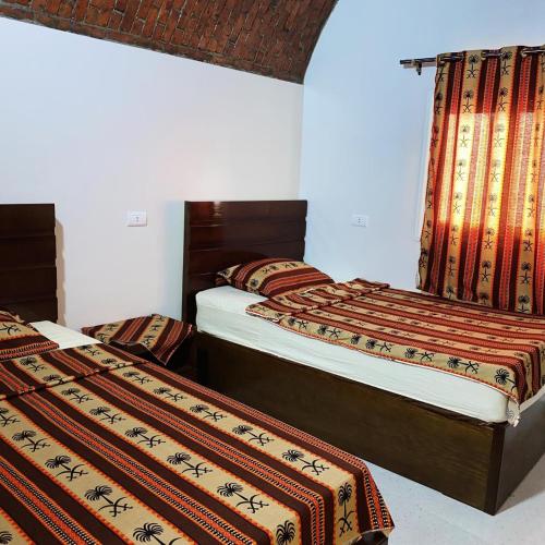 two beds in a room with two beds sidx sidx sidx at nubian yellow desert in Aswan