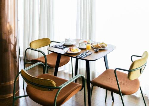a table and chairs with breakfast foods on it at &Tales Hotel - Óbidos in Óbidos