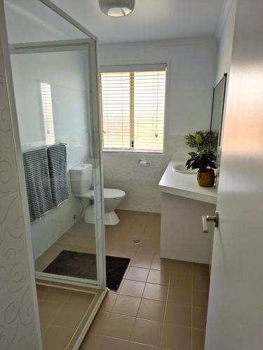 a bathroom with a shower and a toilet and a sink at Beachfront Bliss in Lennox Head