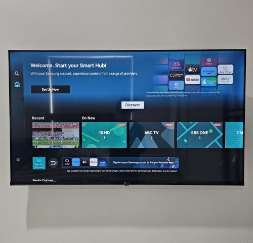 a flat screen tv sitting on a wall at Maruve Guesthouse Plus- Modern Stay near Melb Airport 12 min in Melbourne