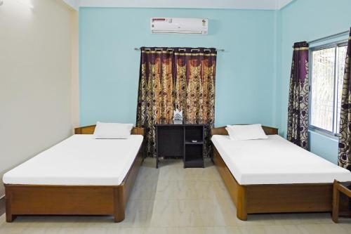 2 Betten in einem Zimmer mit blauen Wänden und Fenstern in der Unterkunft Hotel O Rainbow in Tezpur