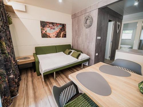 une chambre avec un lit, une table et des chaises dans l'établissement Lake Serenity Premium Mobile Homes-Two Bedroom, à Mostec