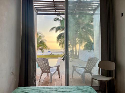 a bedroom with a view of the beach from a window at Over Seas in Barra de Potosi