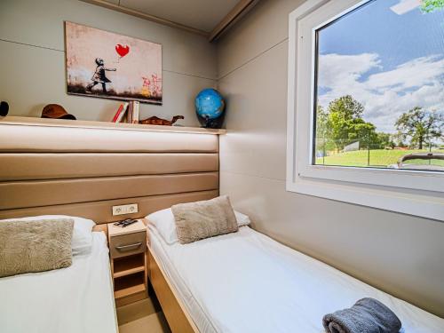 deux lits dans une petite pièce avec une fenêtre dans l'établissement Three Bedroom Mobile Home, à Mostec