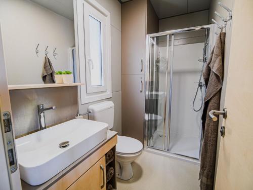 une salle de bain avec toilettes, lavabo et douche dans l'établissement Three Bedroom Mobile Home, à Mostec