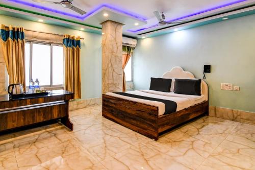 a bedroom with a large bed and a sink at Super Collection O Raj Guest House Near Kolkata Airport in Kolkata