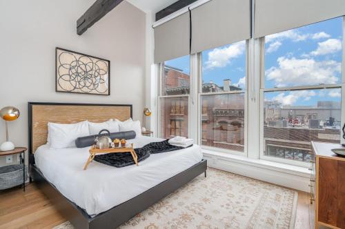 a bedroom with a bed and large windows at The Saddlery - Mic Drop - Walk to Broadway in Nashville