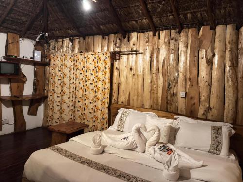 a bedroom with a bed with towel animals on it at Podocarpus Cottages -02 in Naro Moru