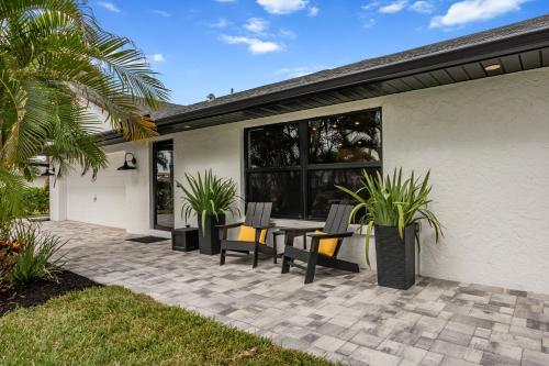 un patio con sillas y una mesa frente a una casa en Near Beach 3BR with King Suite, Pool and BBQ, en Bonita Springs