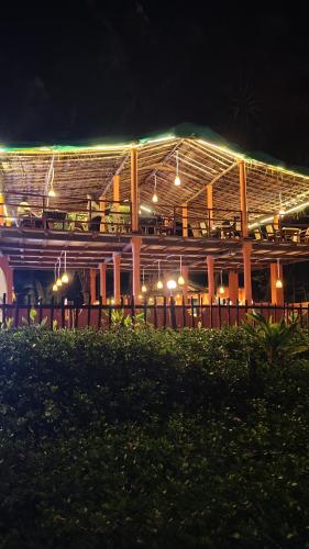 a building with a restaurant at night with lights at Hostel coconut tree in Gokarna