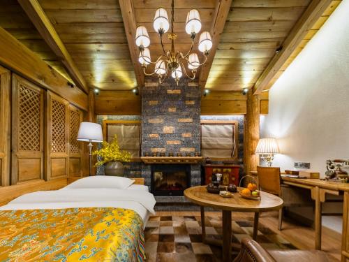 une chambre avec un lit et une cheminée dans l'établissement Floral Hotel Shegadan Manor, à Shangri-La