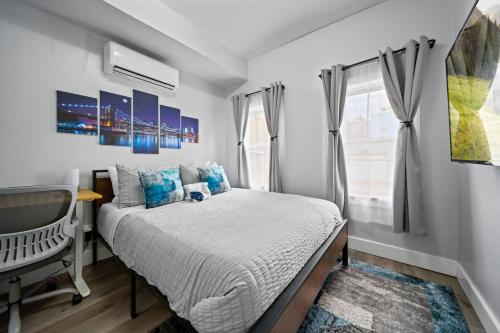 a bedroom with a bed and a desk and a television at Newly renovated luxury 3BR Condo! 30 mins to NYC in Bergen