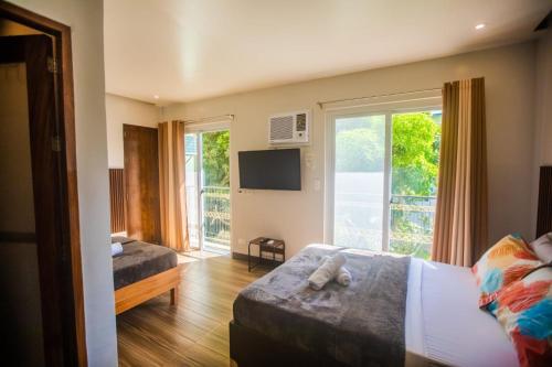 Un dormitorio con una cama y una ventana con un televisor. en Hotel NaeR, en Romblon