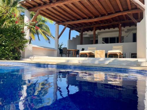 a swimming pool in front of a house at Casa Sta Margarita in Zihuatanejo