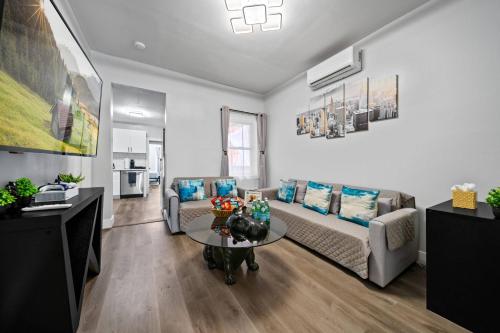 a living room with a couch and a table at Newly renovated luxury 3BR Condo! 30 mins to NYC in Jersey City