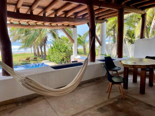 a hammock in a room with a view of the ocean at Casa Sta Margarita in Zihuatanejo